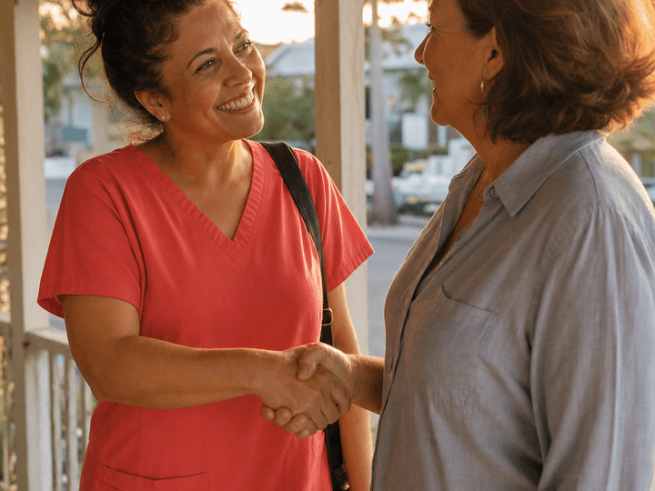 Hospice nurse and family member shaking hands on a porch
